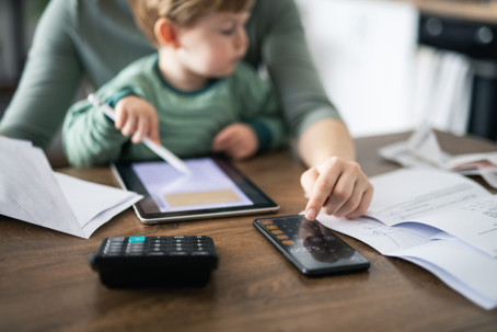 parent calculating expenses with child in their lap